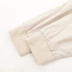 Light beige jacket sleeve end with elasticated cuff and gathered hem.