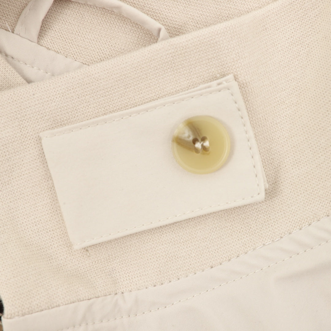 Light beige jacket with cream snap button on inner collar patch label.