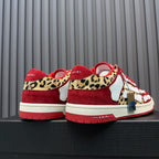 Red and white Amiri sneakers with leopard heel panels and hanging tag