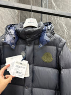 Long hooded puffer jacket close-up, quilted dark fabric with chest logo patch