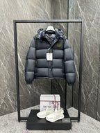 Long hooded puffer jacket with front zip/buttons, dark navy quilted panels, logo patch