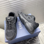 Dior unisex sneakers, side view, dark gray mesh upper and chunky tread sole.