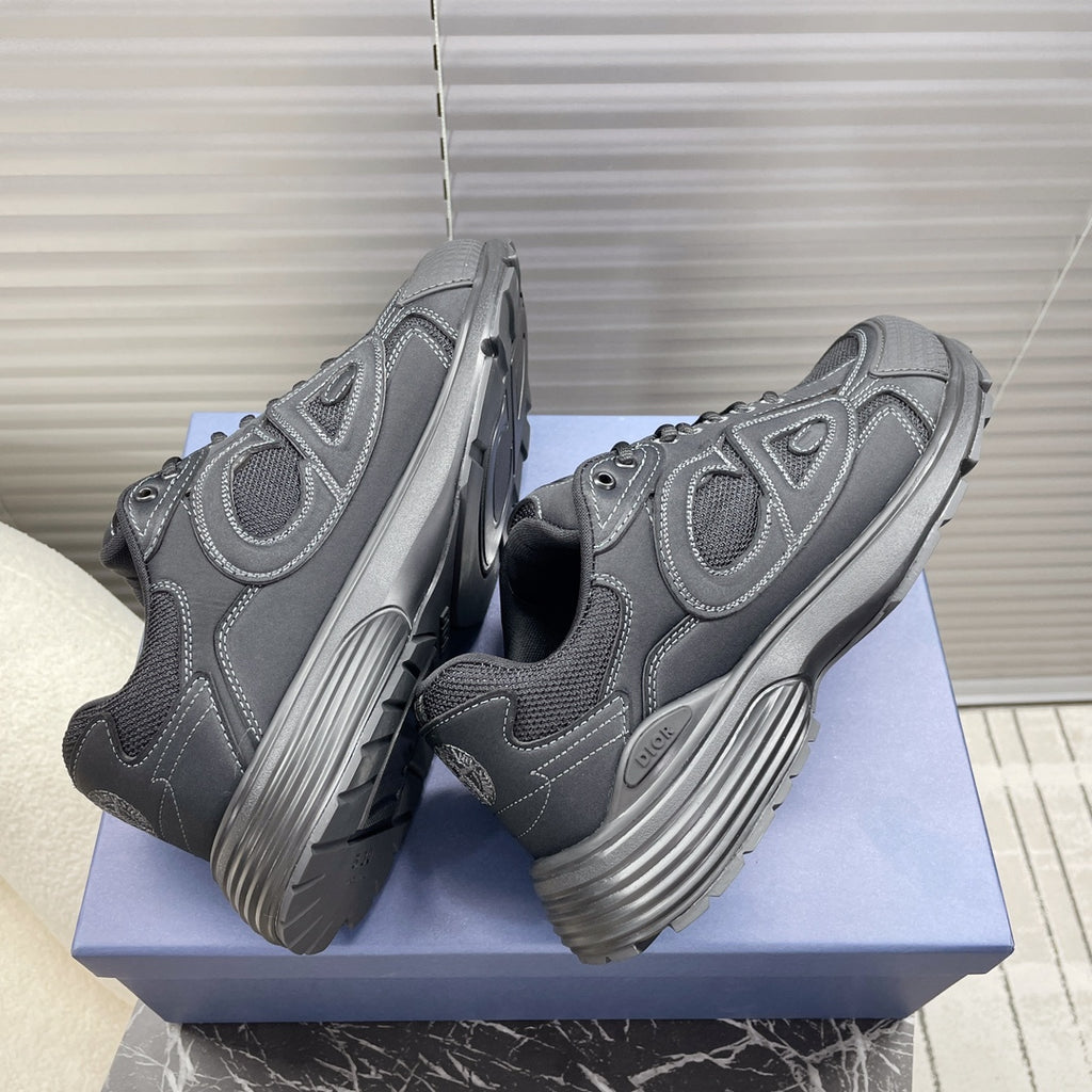 Dior unisex sneakers, front/back angle, dark gray lace-up with logo panels.