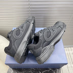 Dior unisex sneakers, front/back angle, dark gray lace-up with logo panels.