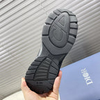 Dior unisex sneakers outsole view, dark gray traction tread with Dior branding.