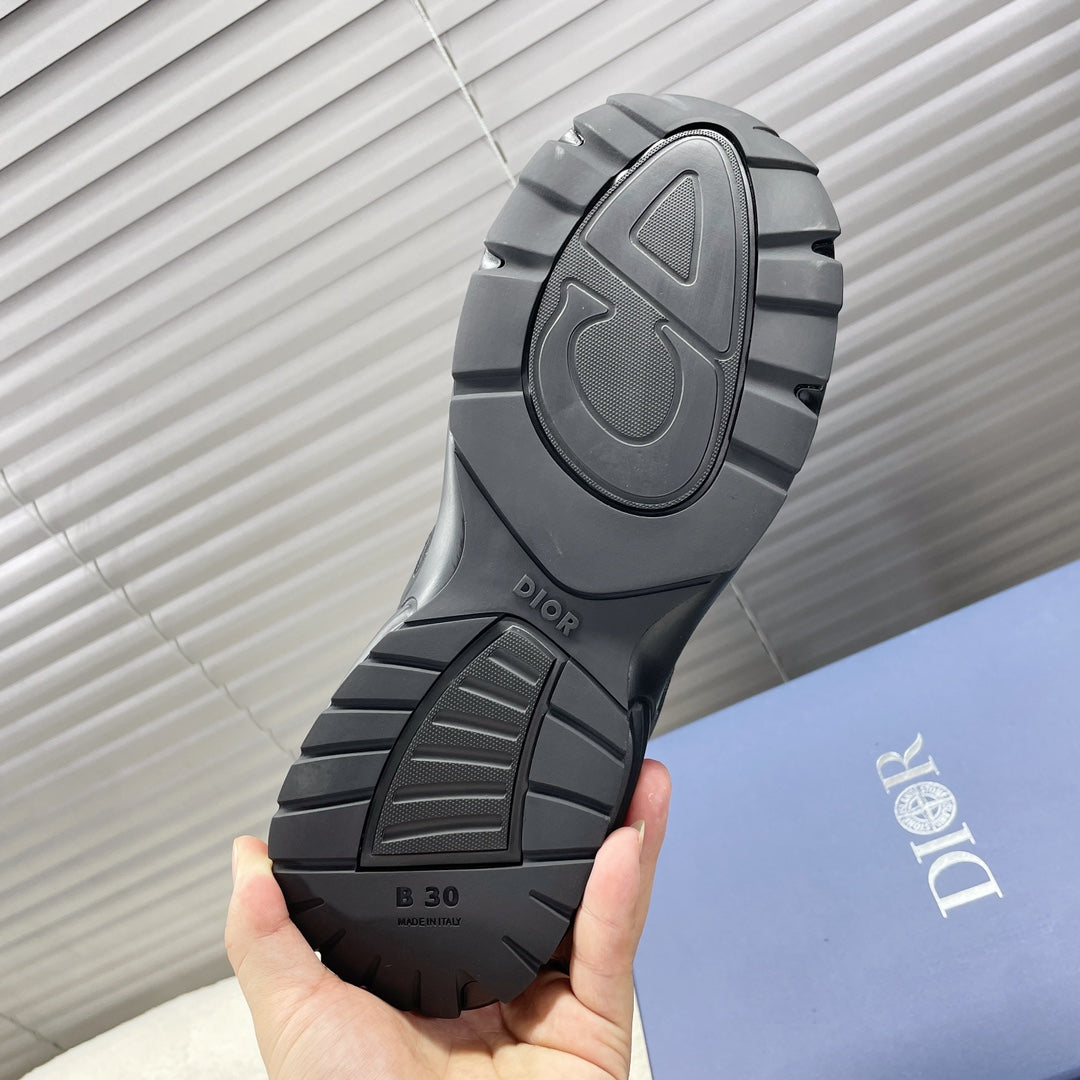 Dior unisex sneakers outsole view, dark gray traction tread with Dior branding.