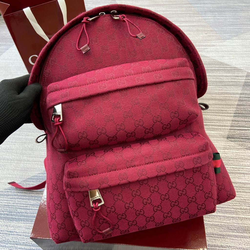 Gucci mini backpack in burgundy with GG monogram, top drawstring, and front zip pocket