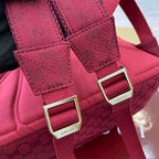 Maroon Gucci backpack strap buckles with metal hardware and 'Gucci' labels.