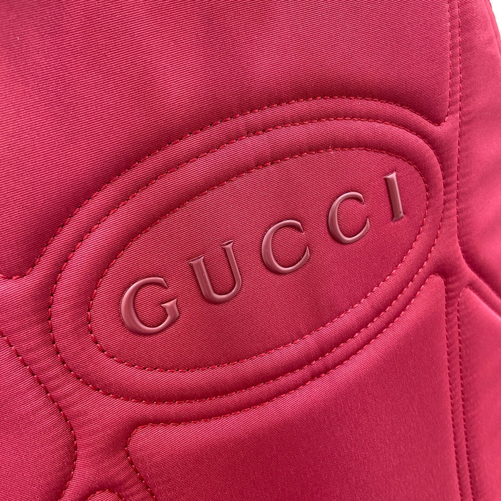 Maroon Gucci backpack lining with embossed 'Gucci' logo patch.