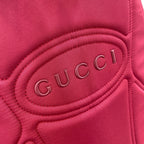 Maroon Gucci backpack lining with embossed 'Gucci' logo patch.