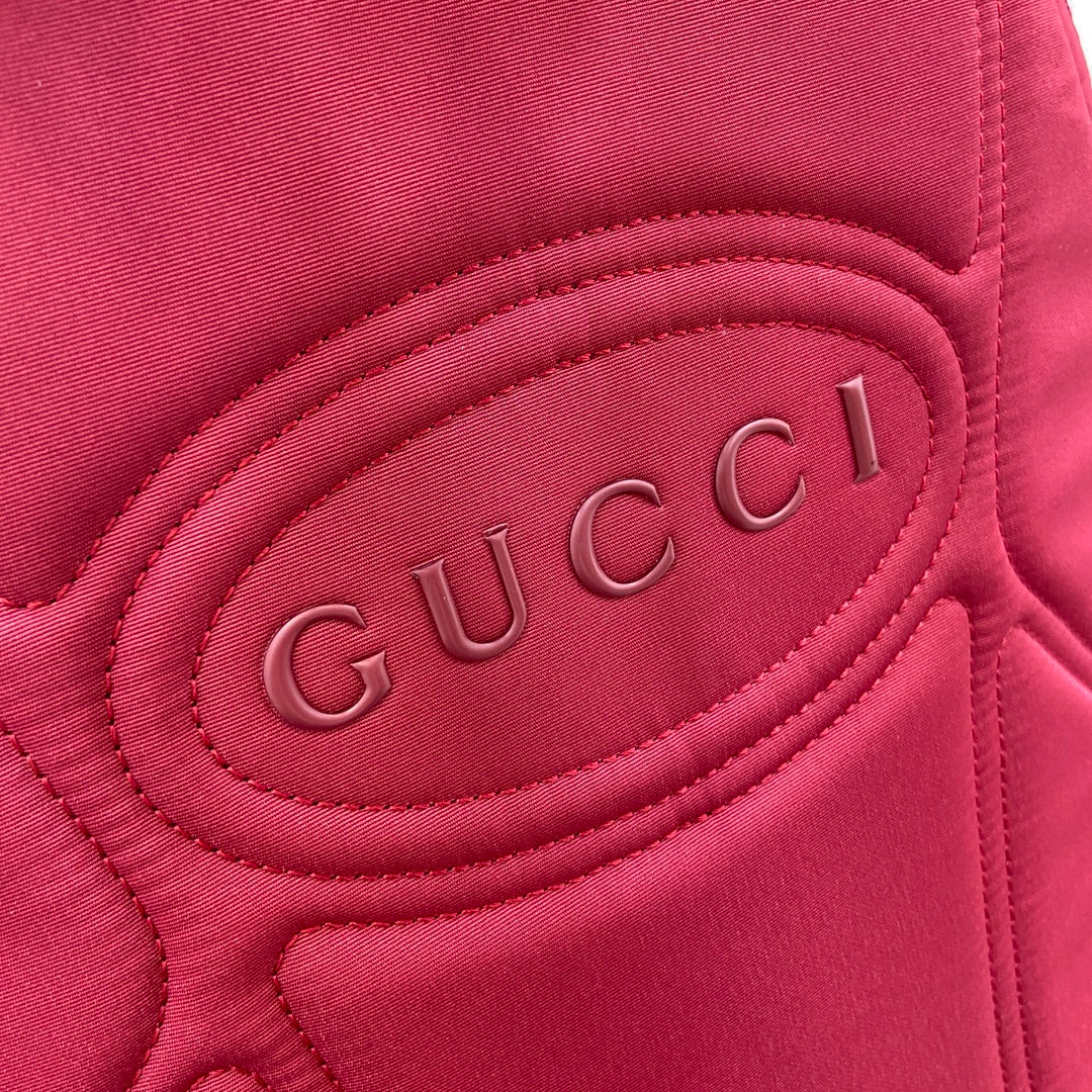 Gucci mini backpack interior panel in burgundy with embossed “Gucci” logo padding