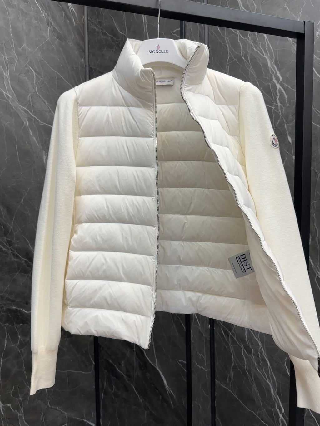 Moncler long padded jacket close-up, light white front with small logo patch