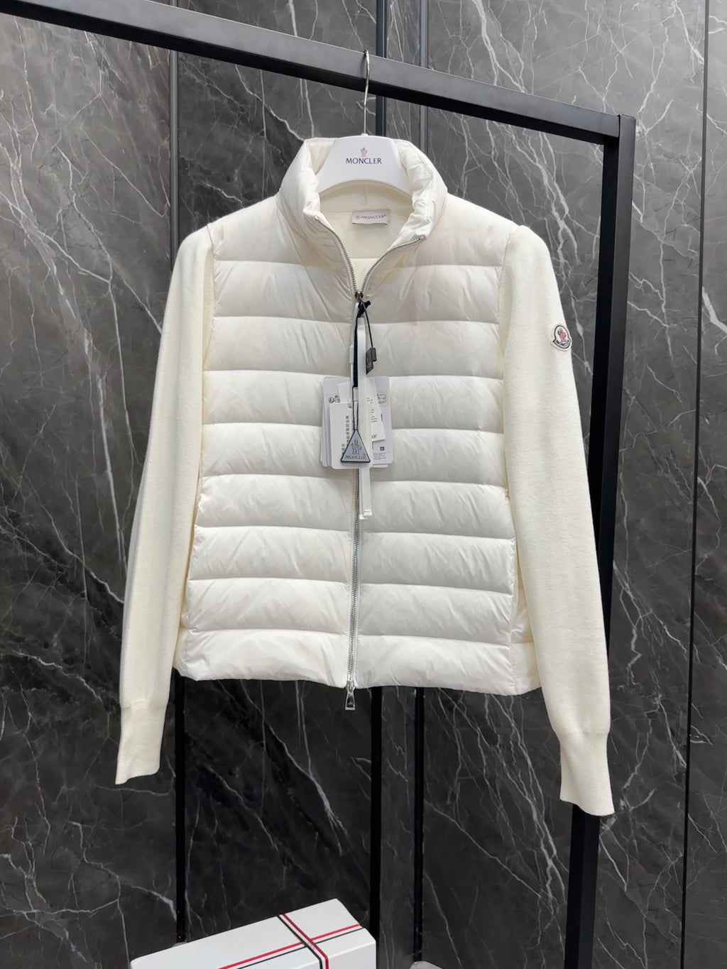 Moncler long padded jacket front view, light white with hang tag at the zipper