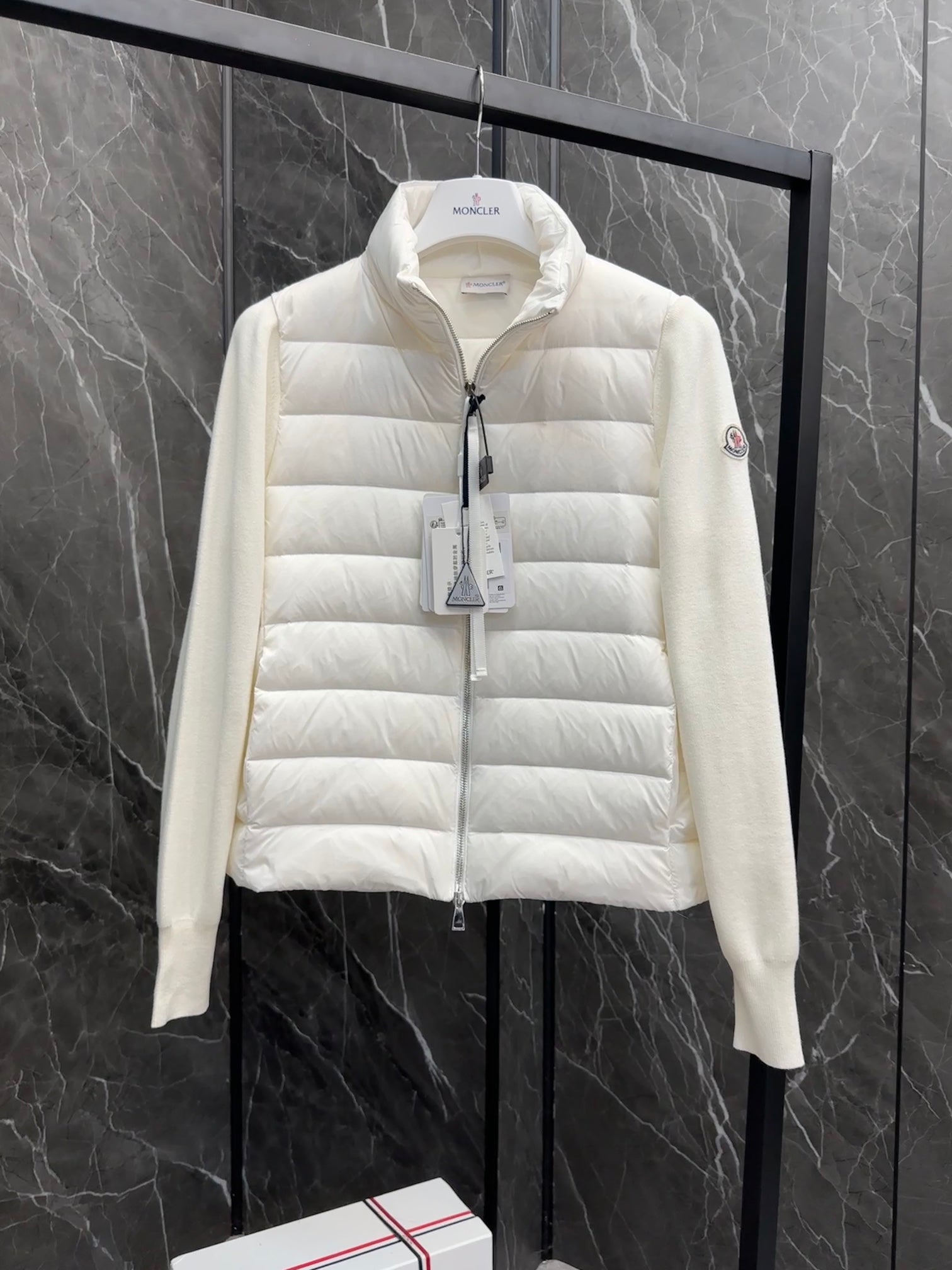 Moncler long padded jacket front view, light white with hang tag at the zipper