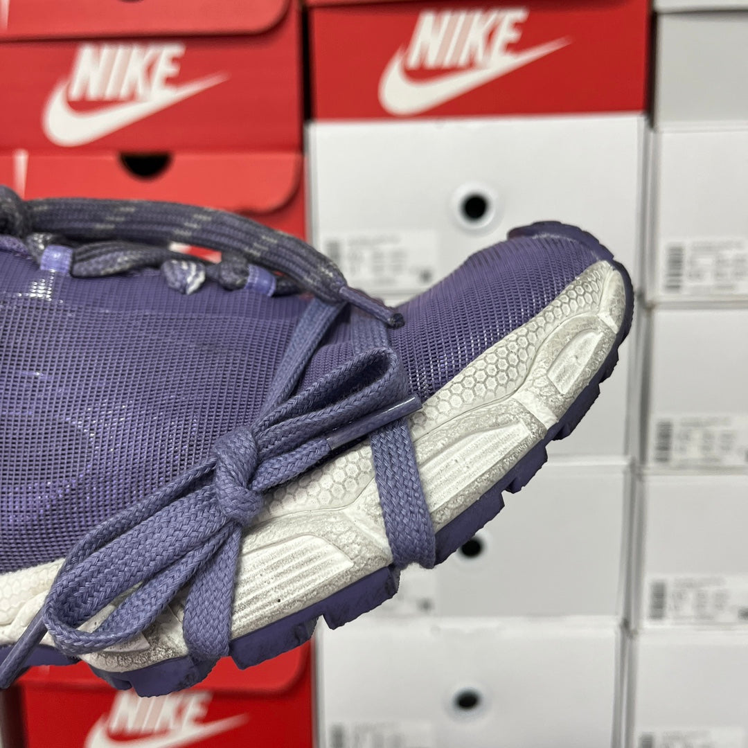 Dark blue knit sneaker with close-up of silver textured heel and laces