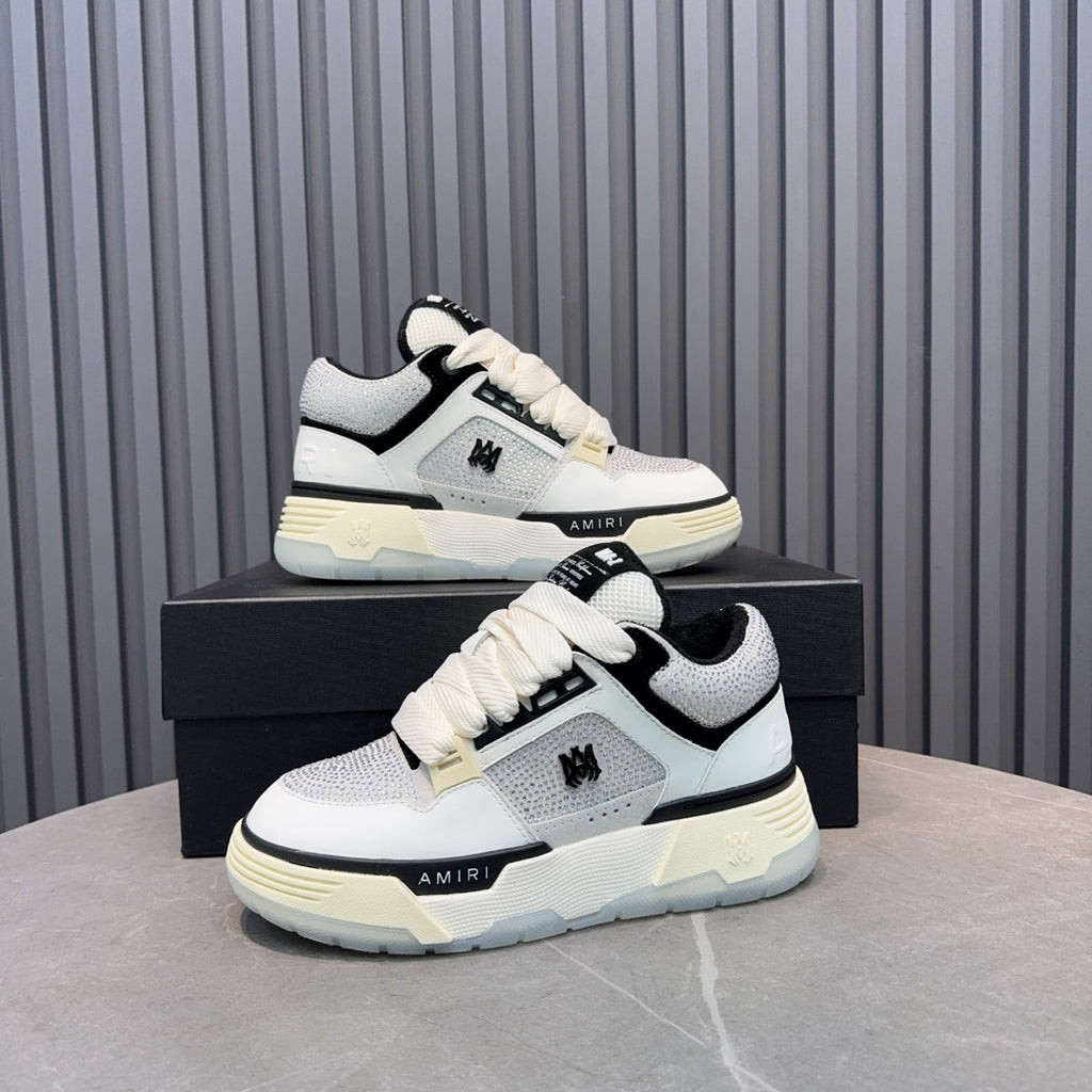 White and black lace-up sneakers with cream sole, AMIRI logo on side panel.