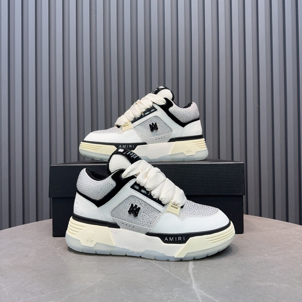 White and black lace-up sneakers with cream midsole and side AMIRI logo.