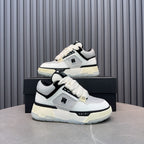 White and black lace-up sneakers with cream midsole and side AMIRI logo.