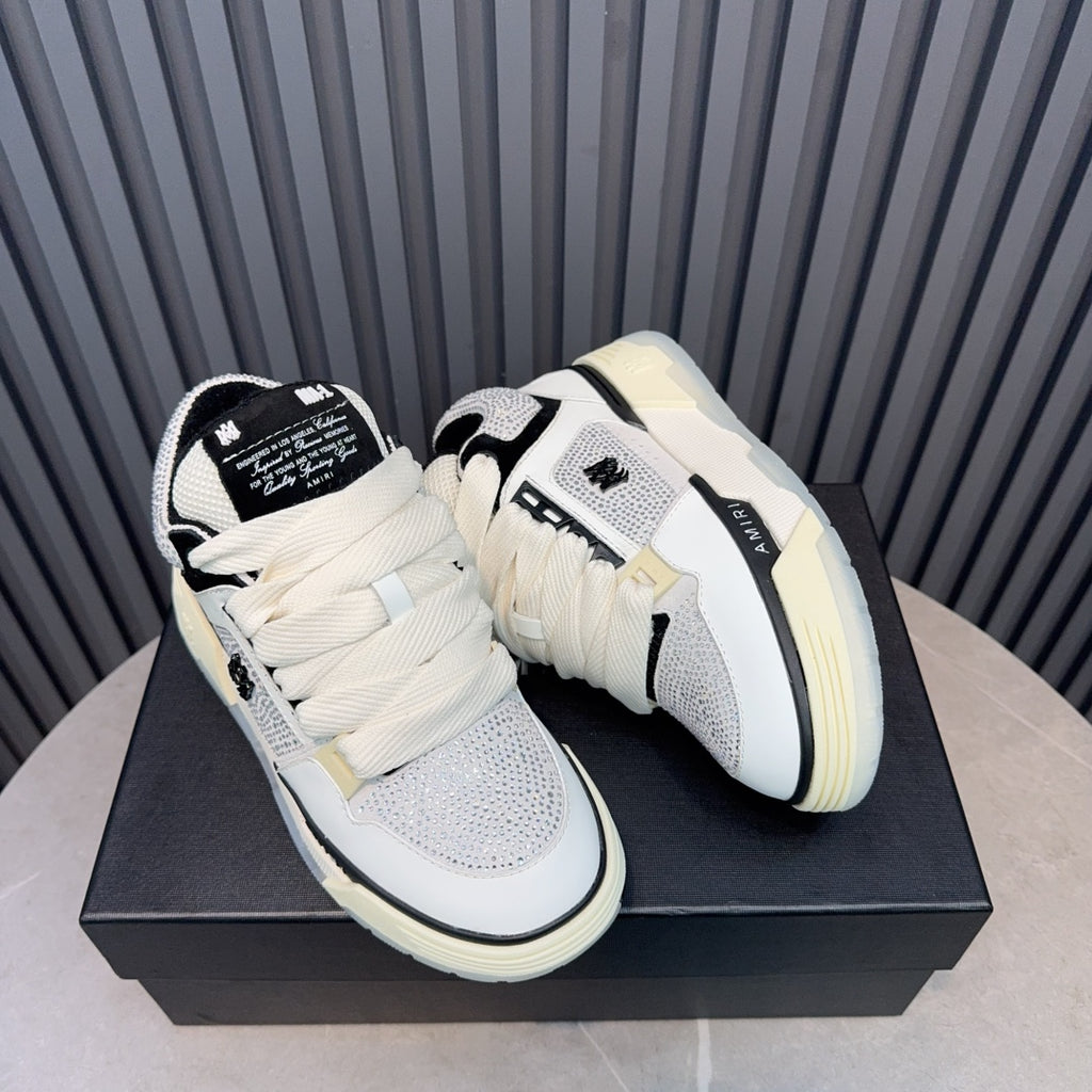 Pair of white and black low-top sneakers with cream sole and lace-up straps.