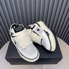 Pair of white and black low-top sneakers with cream sole and lace-up straps.