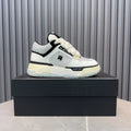 White and black lace-up sneakers with cream sole, AMIRI logo on side.