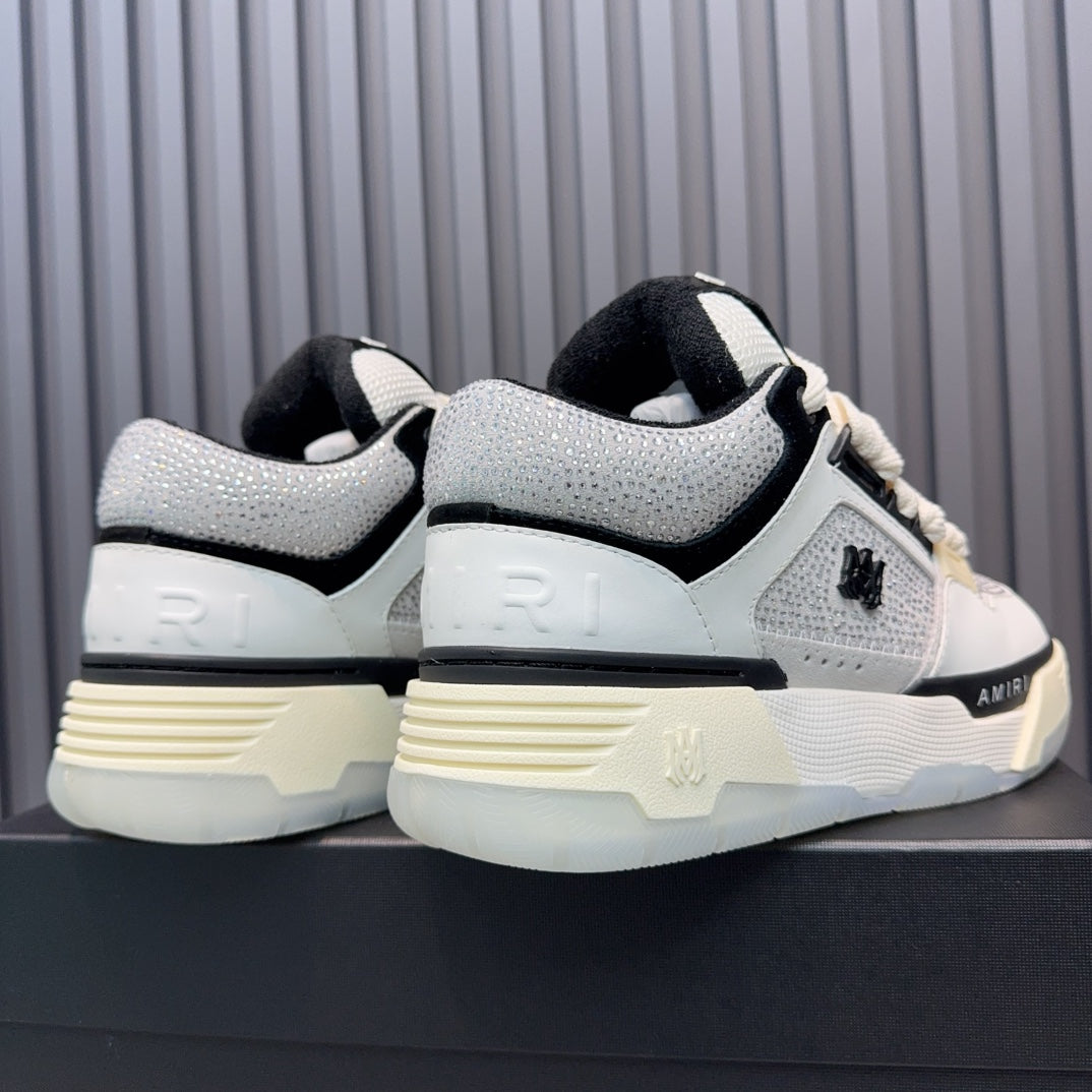 Back view of white and black sneakers with cream sole tread and heel branding.