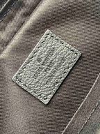 Louis Vuitton bag interior label on textured gray fabric with embossed logo
