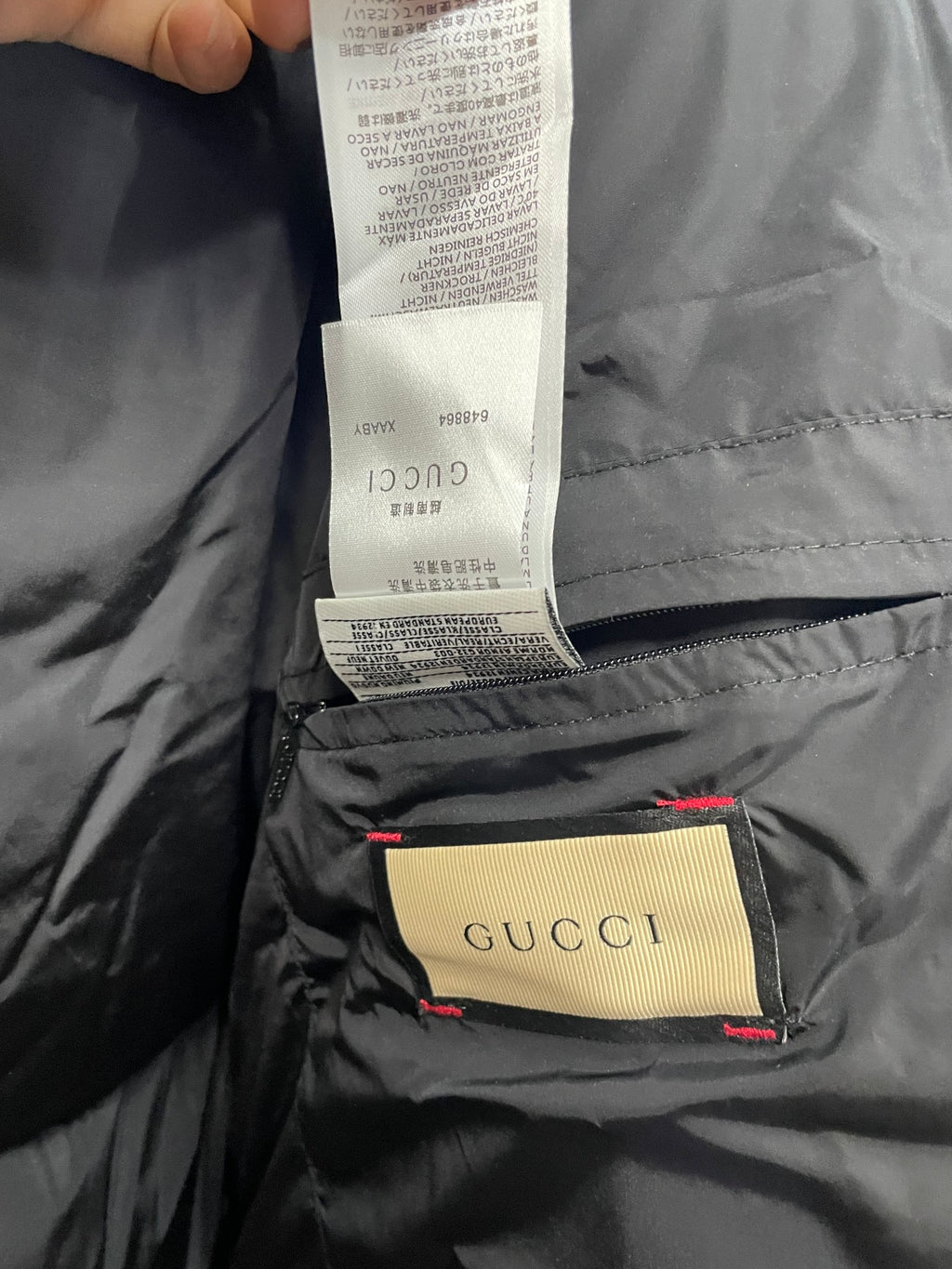 Black puffer jacket lining with Gucci tag and care label sewn inside