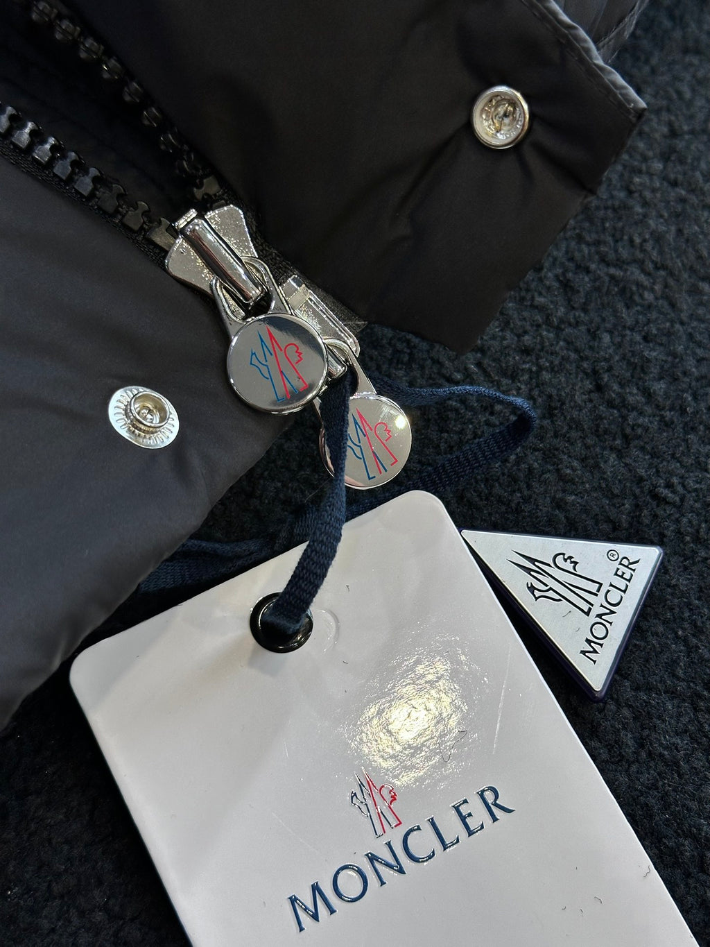 Black puffer jacket front zipper with metal pull and logo snap buttons