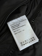 Black puffer jacket care label tag with size and fabric icons