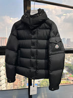 Long puffer jacket in dark black with hood, front zip, and chest logo patch