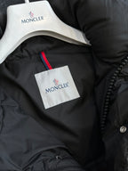 Black puffer jacket neck lining with white tag and red logo trim