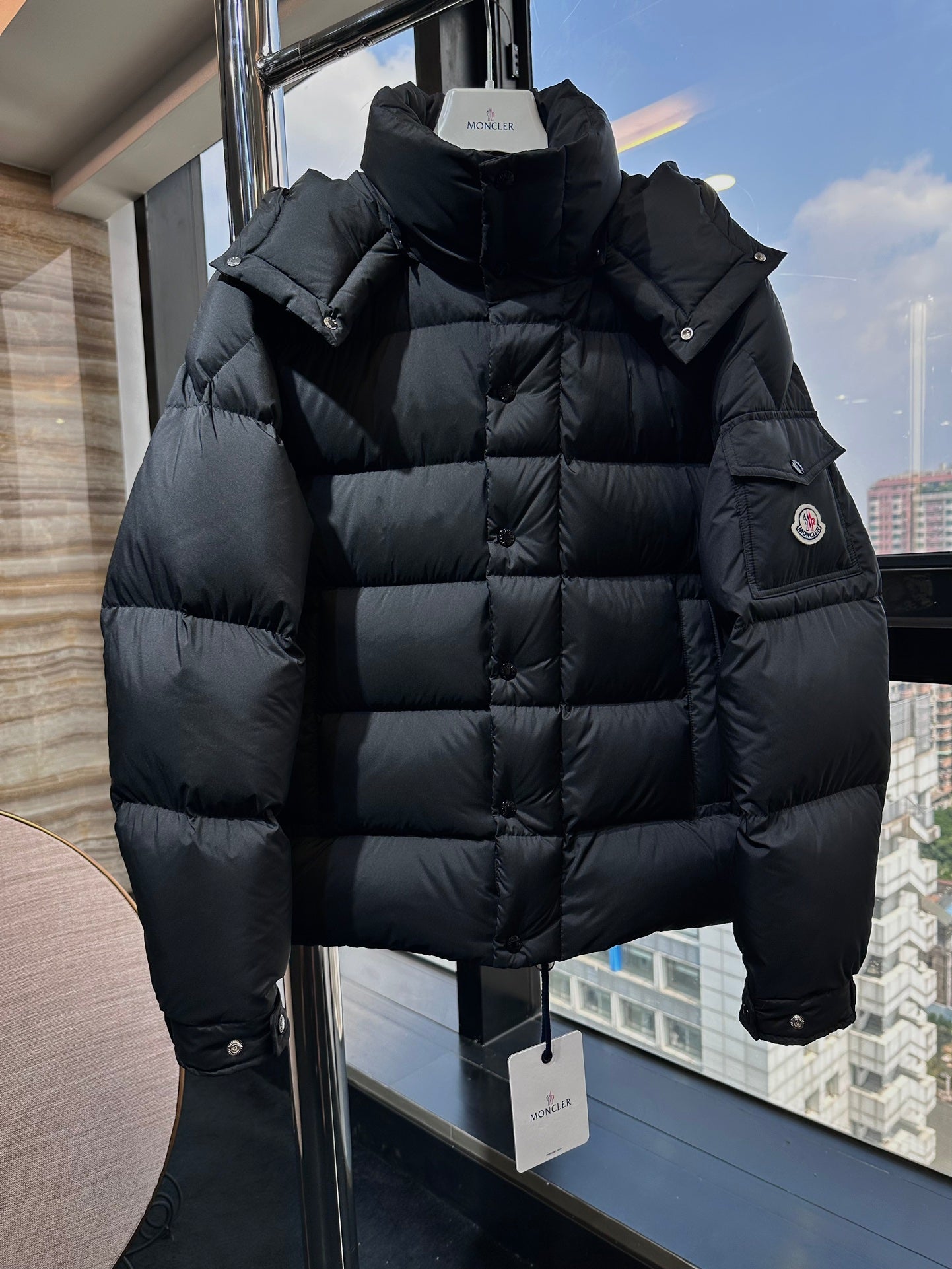 Long puffer jacket in dark black with stand collar and front button placket