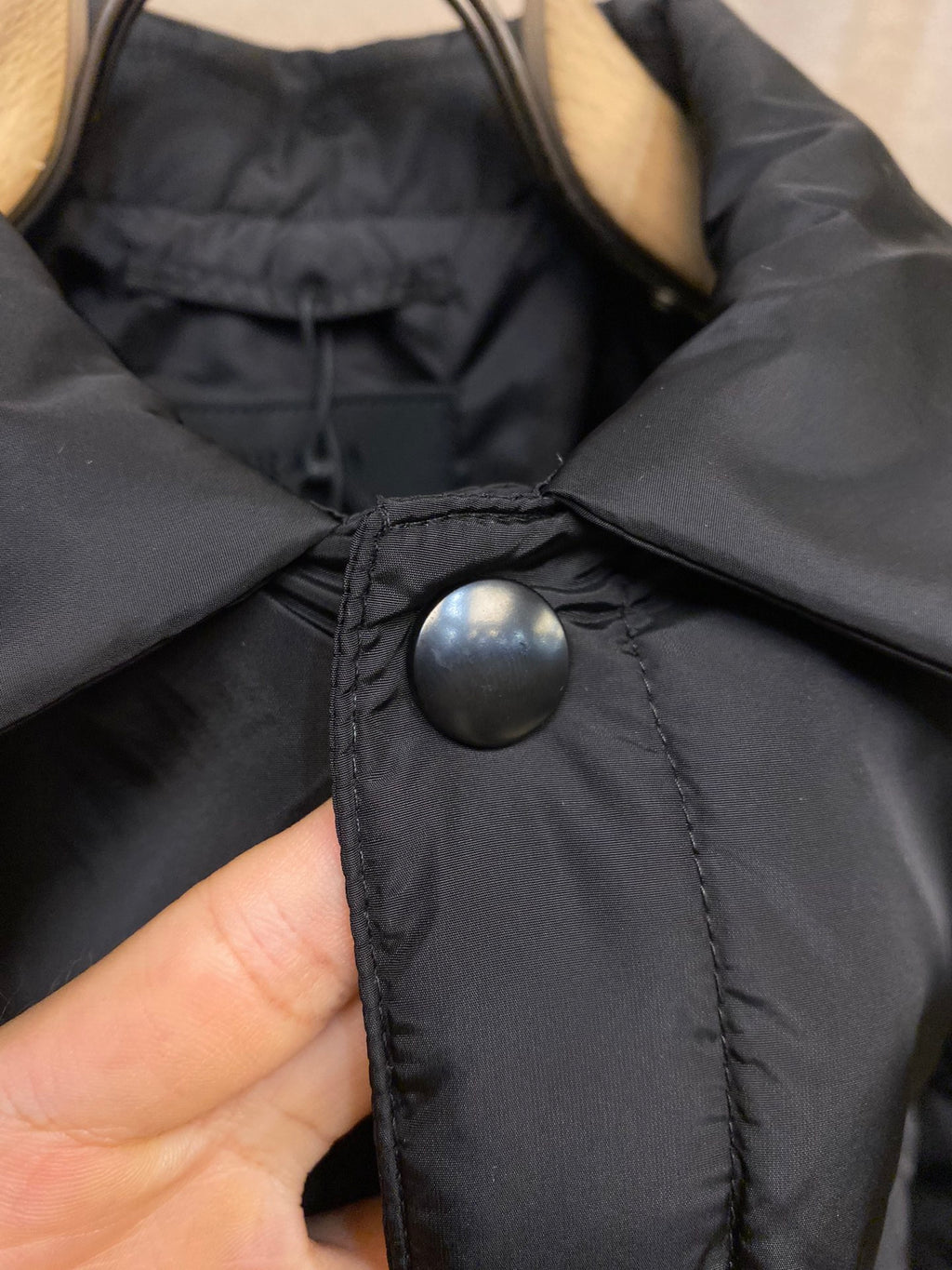 Prada long nylon jacket, dark color, close-up of snap button on collar