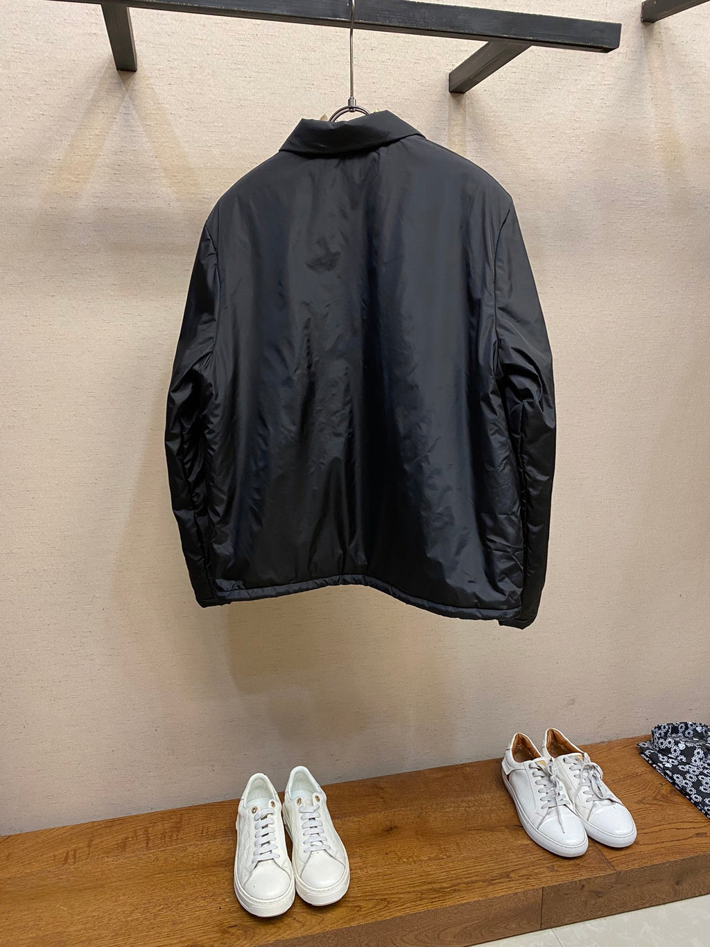 Prada long nylon jacket in dark color, back view on hanger