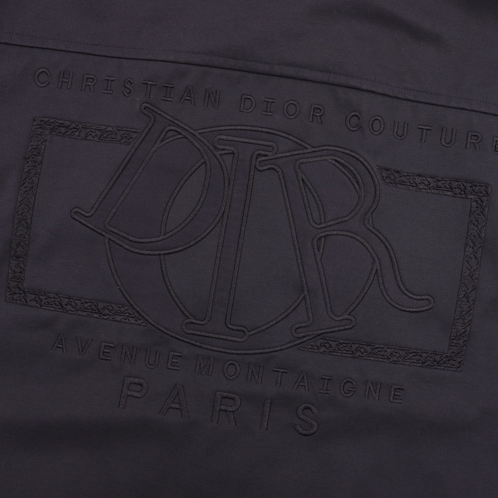Dior logo engraving detail on the front of a dark jacket