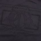 Dior logo engraving detail on the front of a dark jacket
