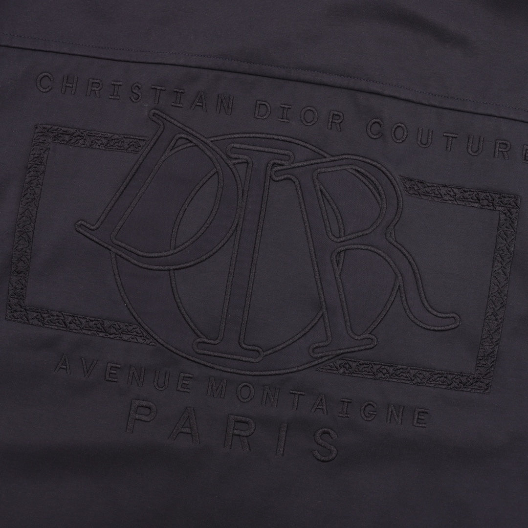 Dior logo engraving detail on the front of a dark jacket