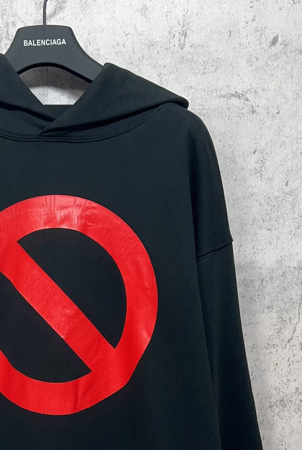Balenciaga long hoodie sleeve, dark with partial red circle-and-slash logo