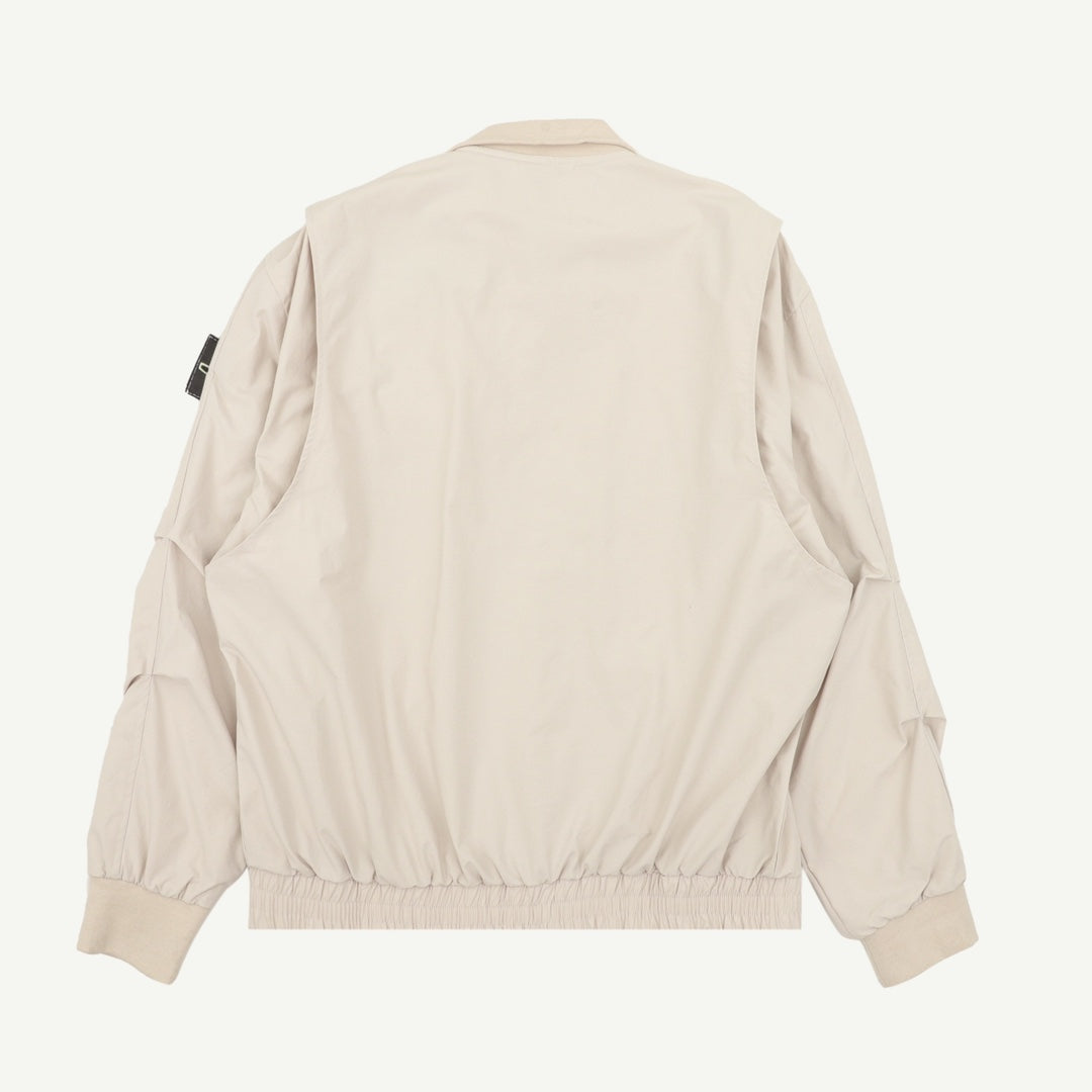 Light beige zip-up jacket back view with ribbed cuffs and elastic hem