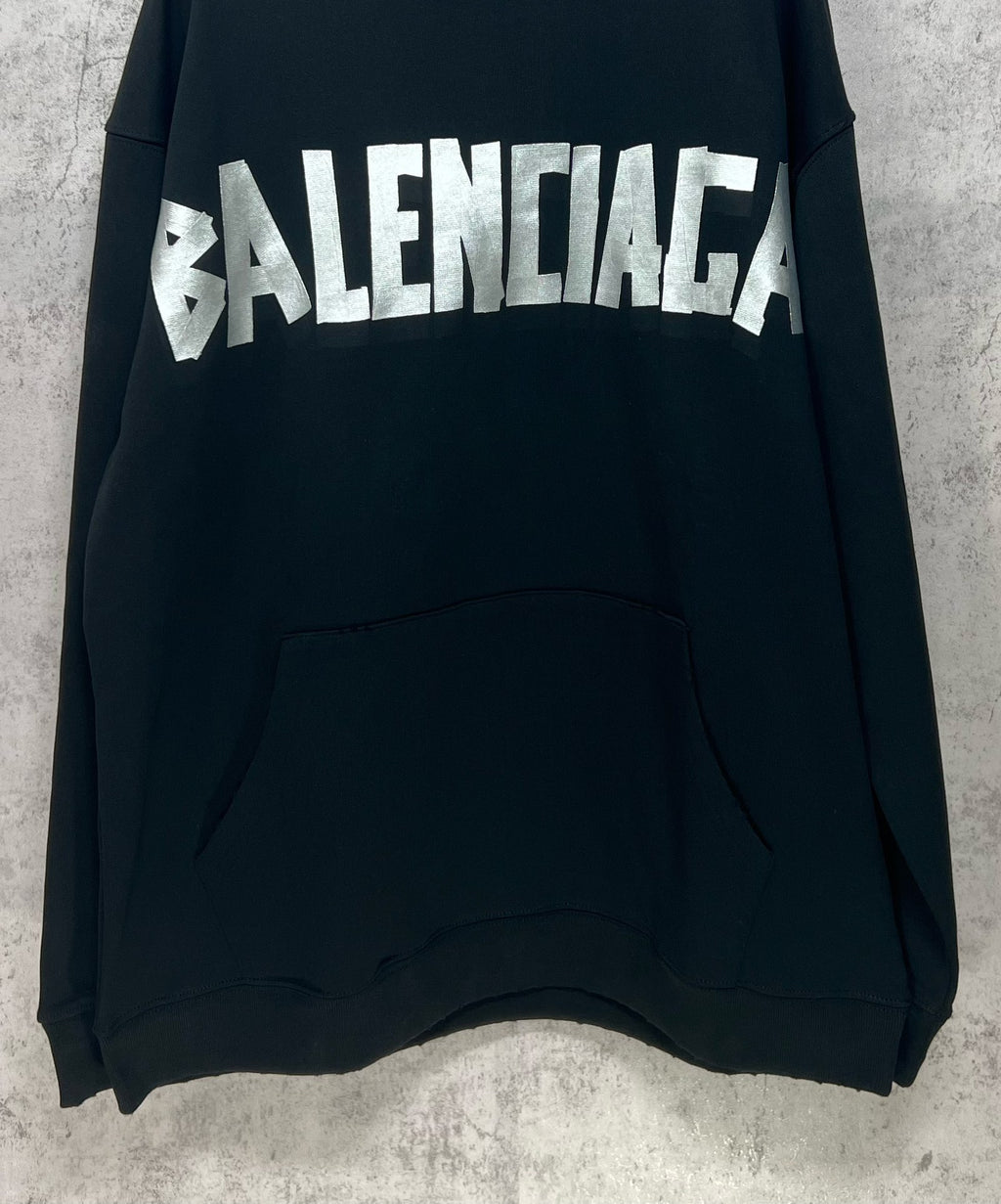 Black long-sleeve hoodie with large white Balenciaga logo and front kangaroo pocket