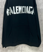 Black long-sleeve hoodie with large white Balenciaga logo and front kangaroo pocket