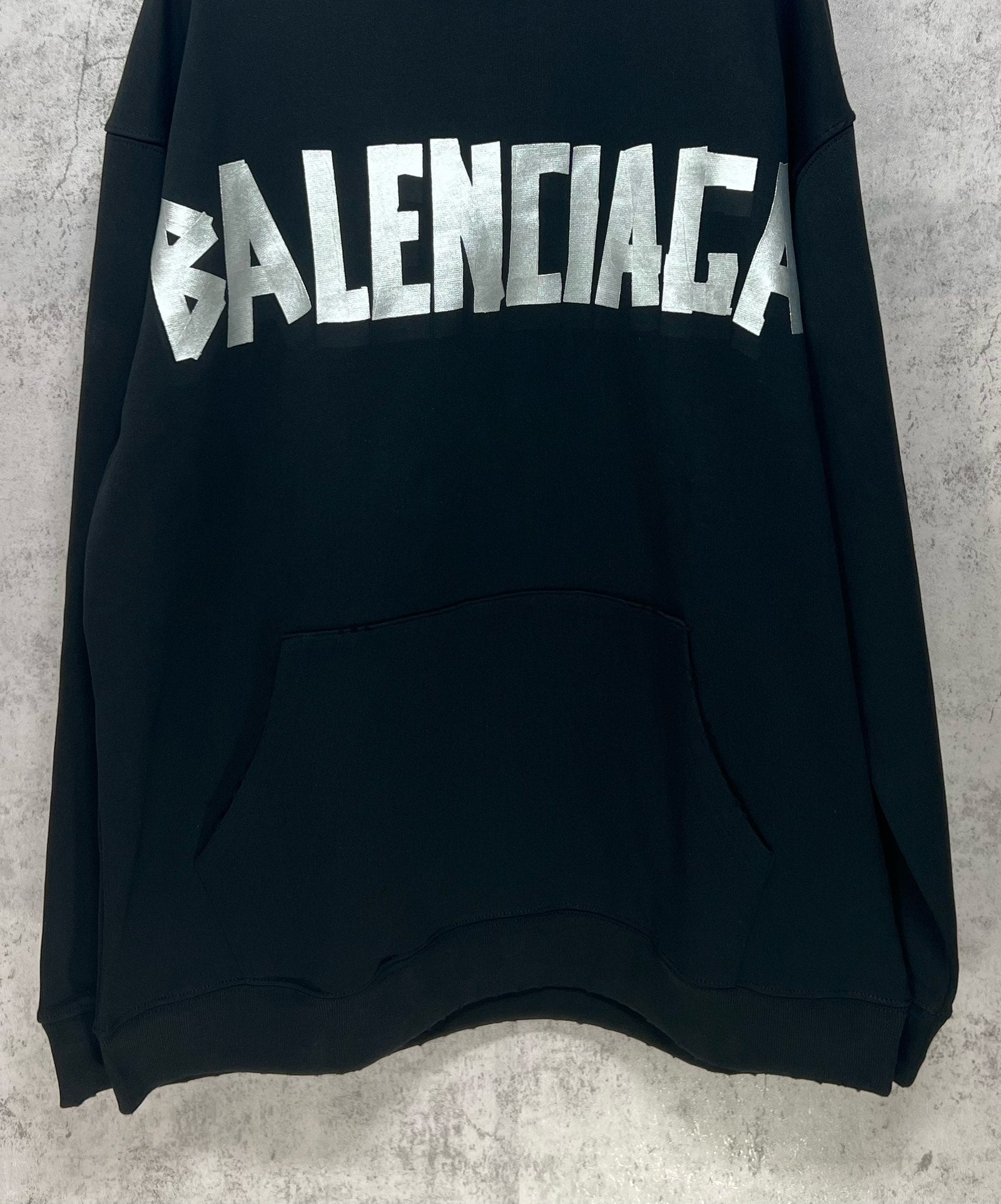 Black long-sleeve hoodie with large white Balenciaga logo and front kangaroo pocket