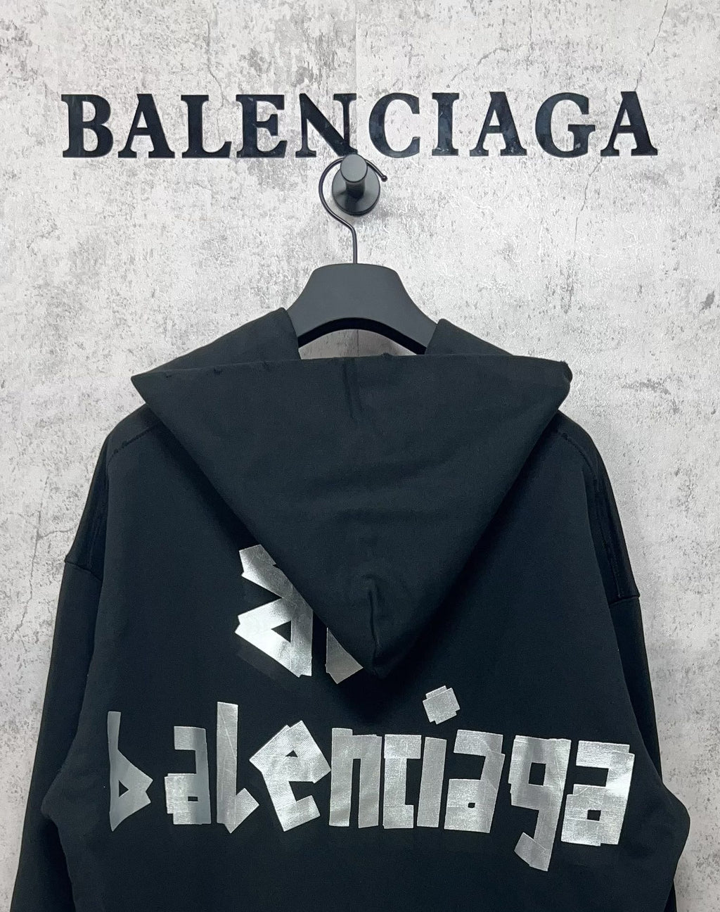 Black hoodie with hood and white Balenciaga logo print on the back