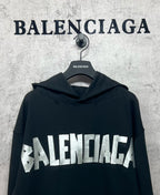 Black long-sleeve hoodie with white Balenciaga logo print across the chest