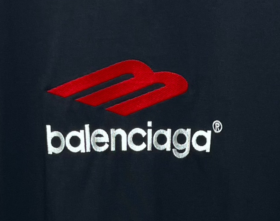 Balenciaga logo graphic on dark T-shirt fabric with red mark and white text