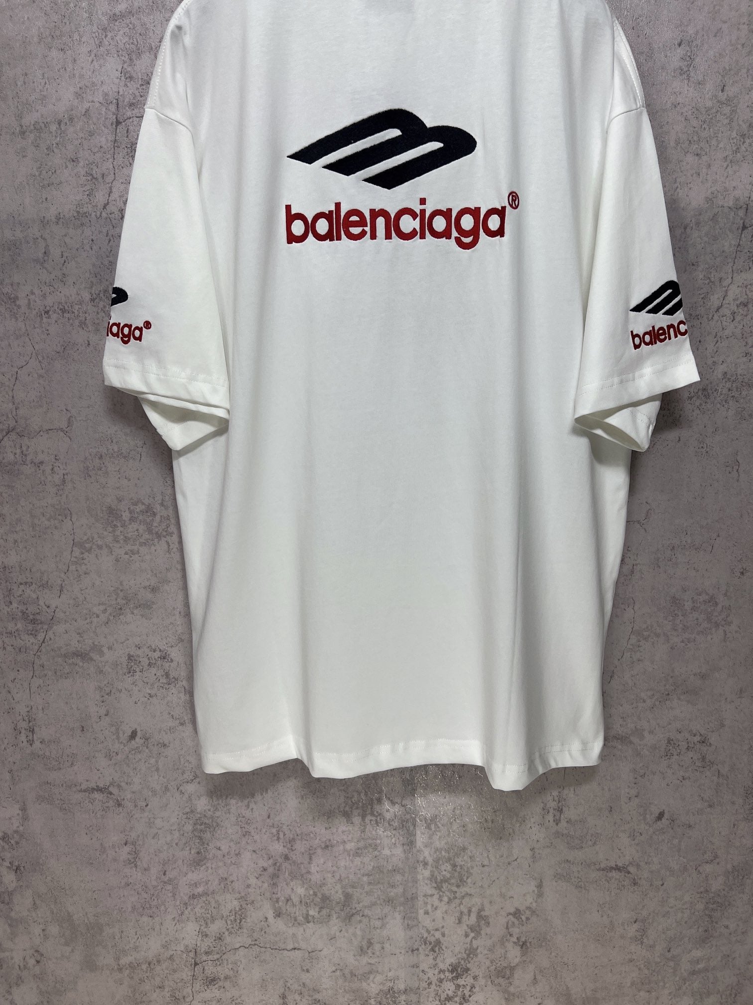 White short-sleeve T-shirt back view with Balenciaga logo and side sleeve print.