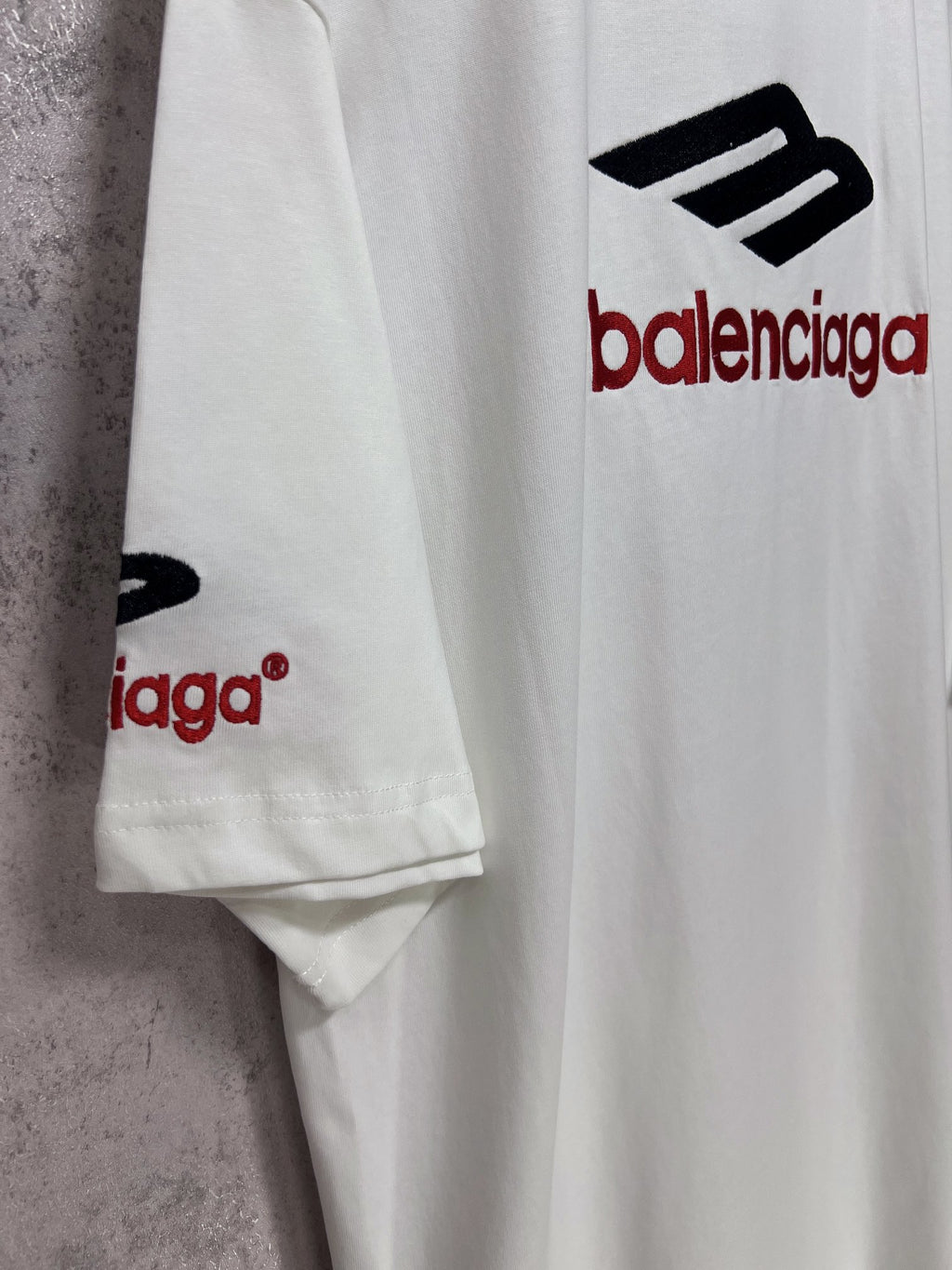 White short-sleeve T-shirt sleeve detail with partial Balenciaga logo.