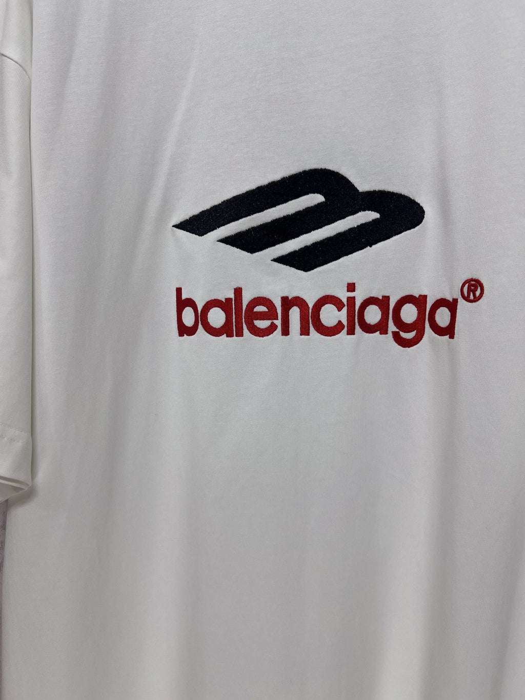 Close-up of Balenciaga logo print on white short-sleeve T-shirt.