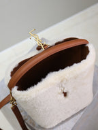 Cream shearling-look YSL bag with gold YSL logo on brown strap, open interior